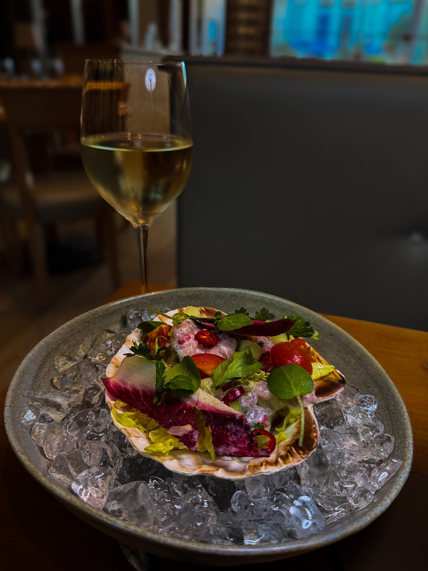 Bream ceviche with coconut, chilli, cucumber and coriander, served in a scallop shell on crushed ice