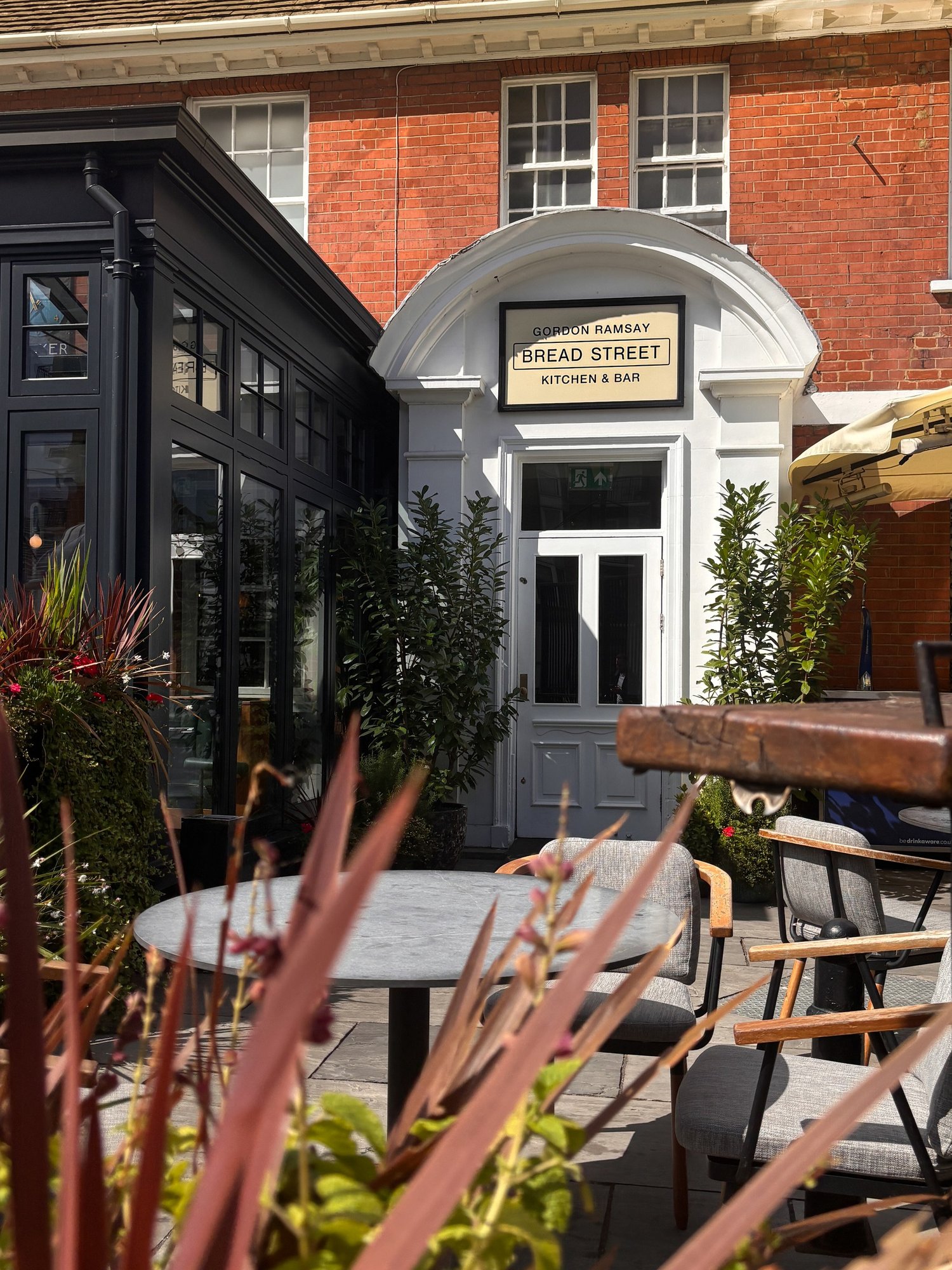 The exterior of Bread Street Kitchen and Bar Limehouse with terrace seating and planting