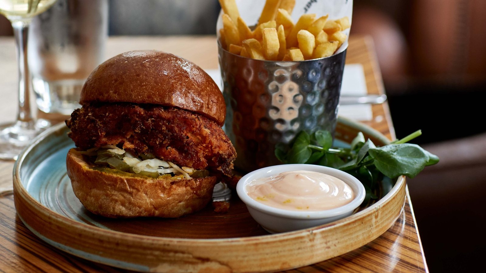A burger and fries served on a wooden board at bbar