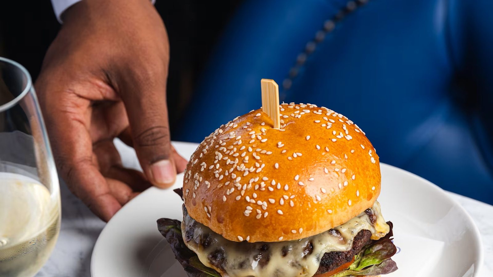 A Richoux Cheese Burger on a branded plate, with fries