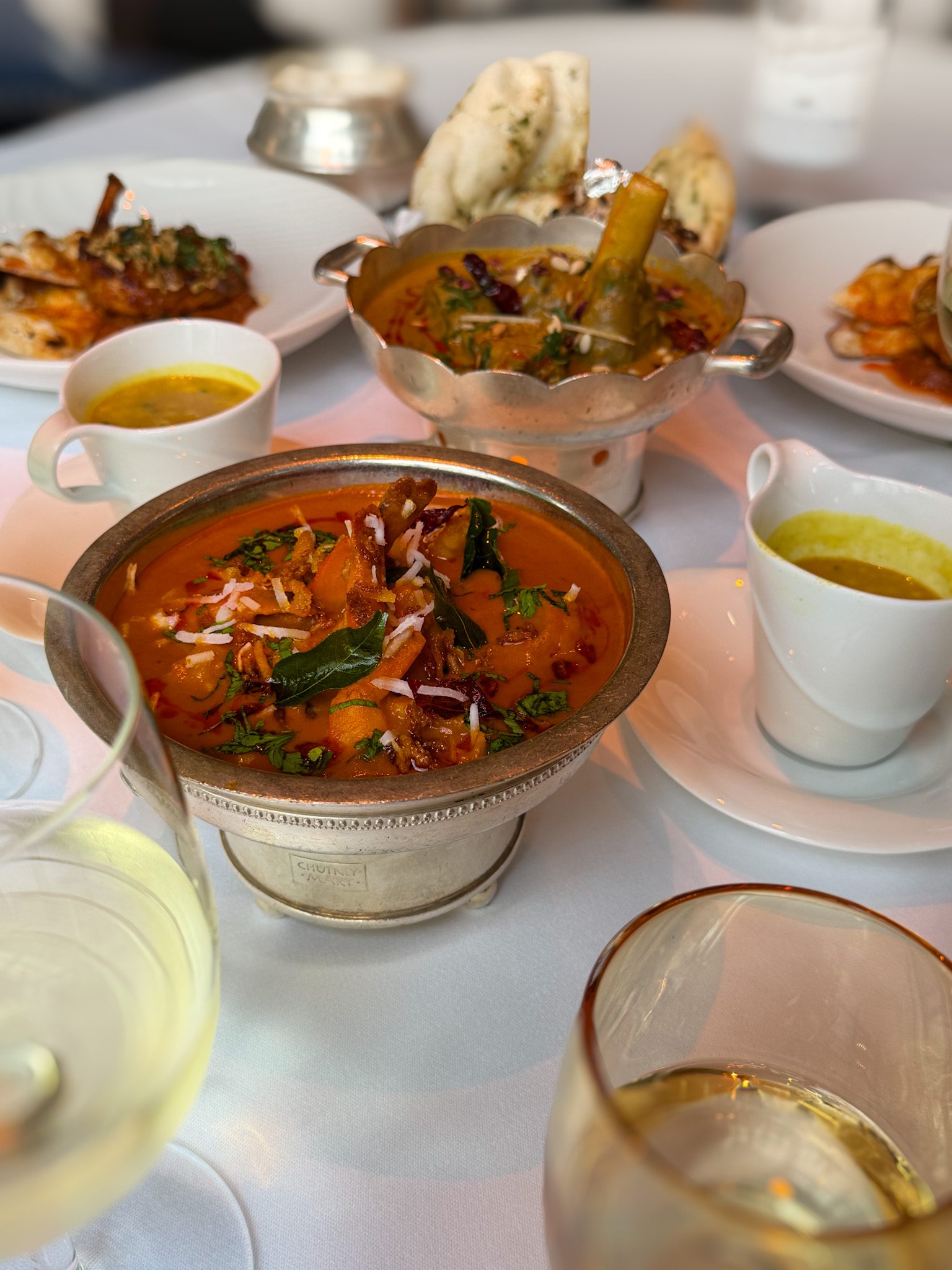 The mulligatawny soup in a cup, the Hyderabadi lamb salan in its silver bowl and naan on the table