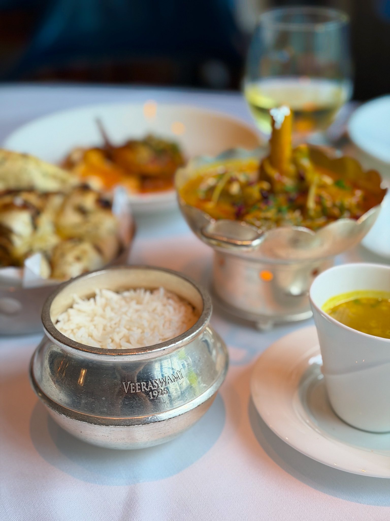 Silver pot of basmati rice stamped Veeraswamy 1926 beside the lamb salan